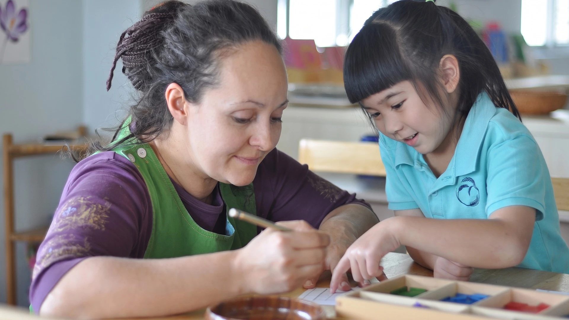 Yuliya supporting a child with a Montessori activity